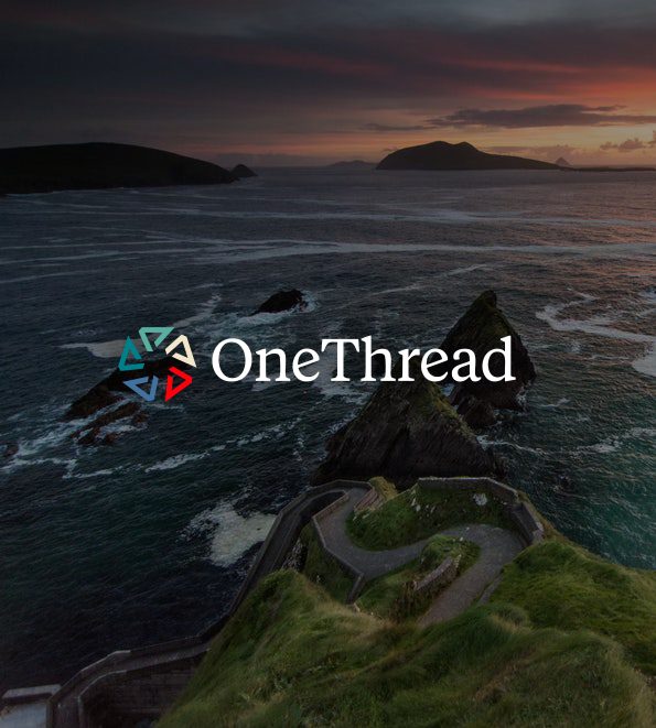 The OneThread mark over the Irish coastline at dusk