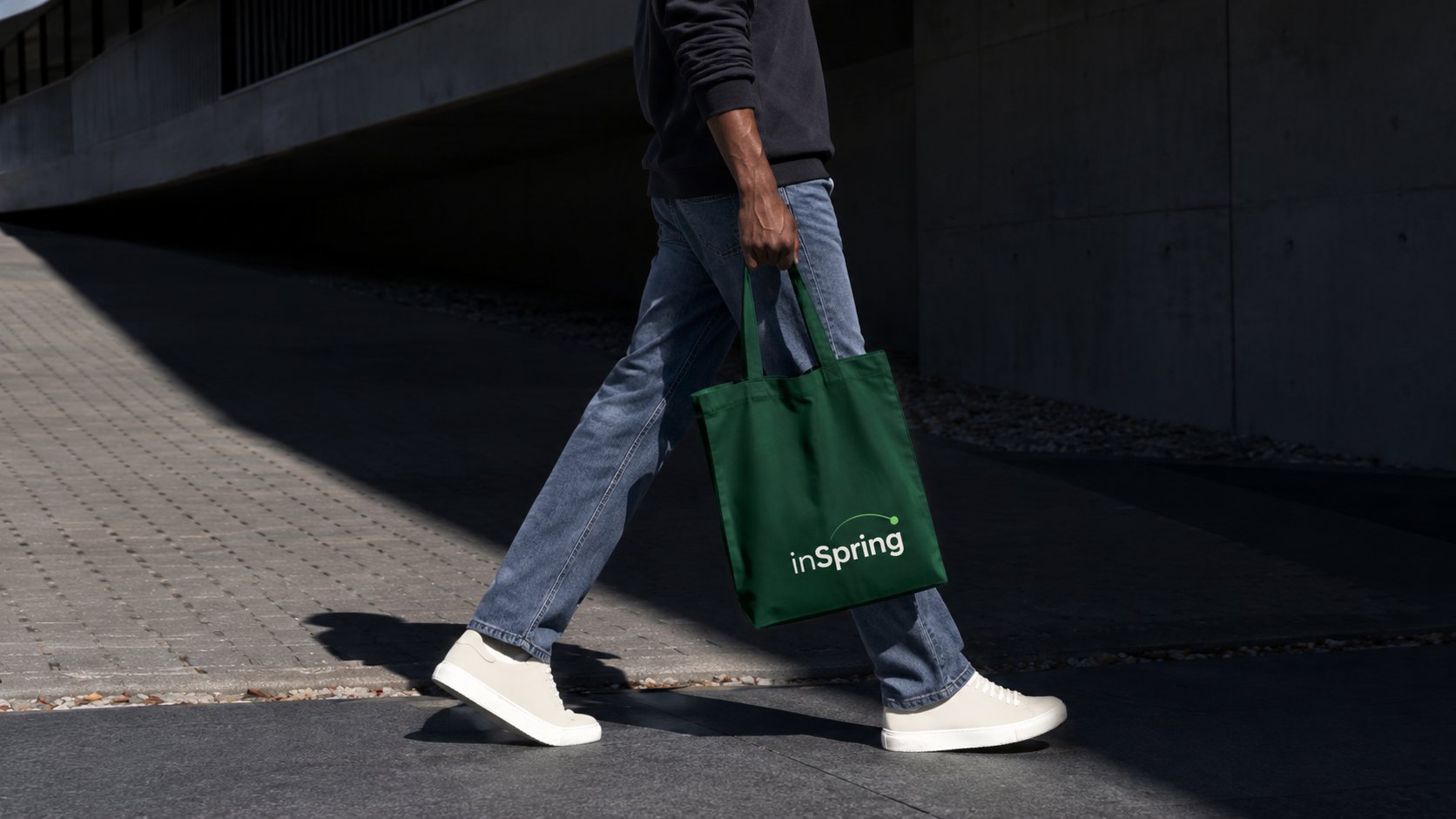 A green inSpring tote bag, carried down a sunlit street