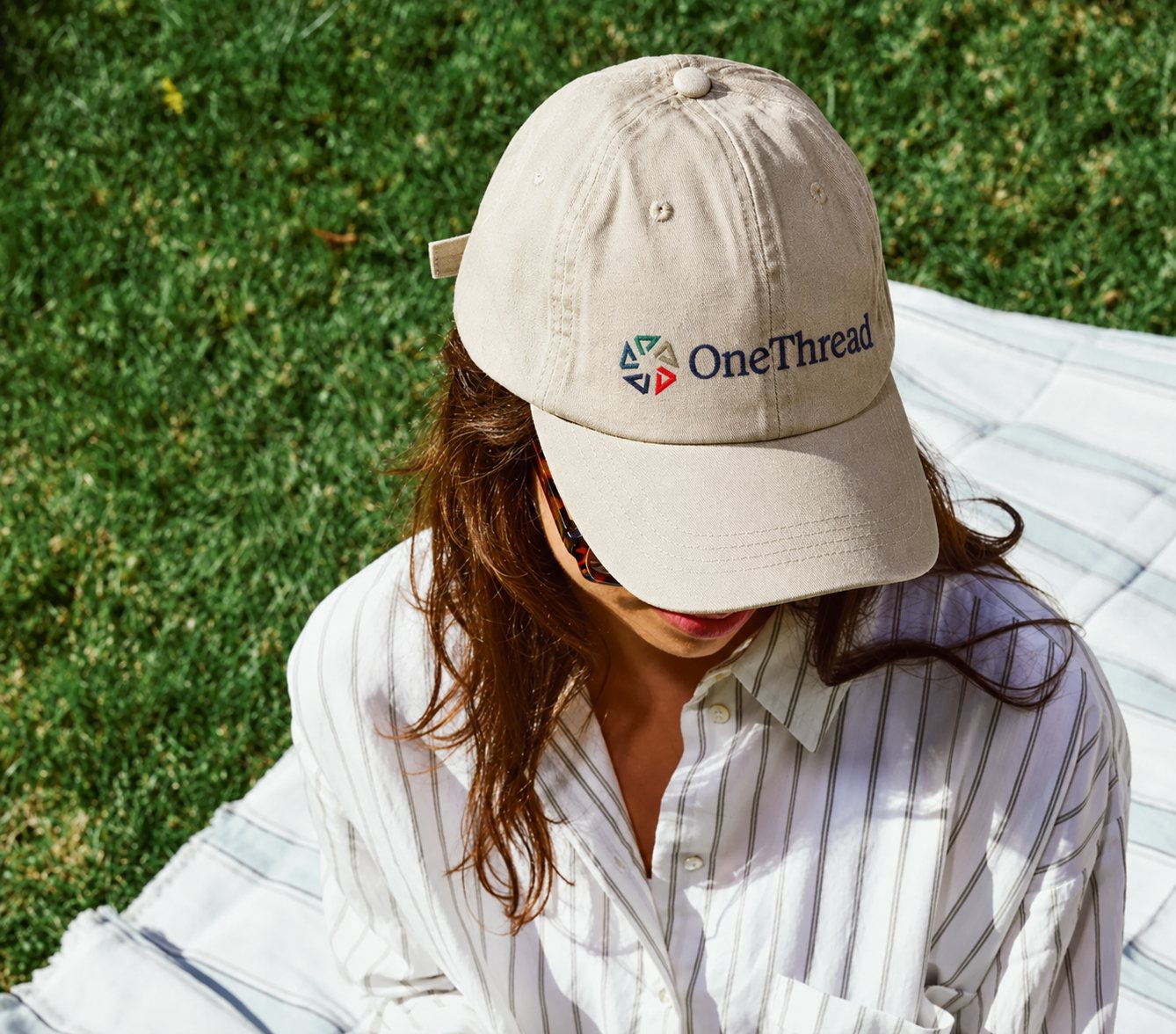 A stone-coloured cap embroidered with the OneThread mark