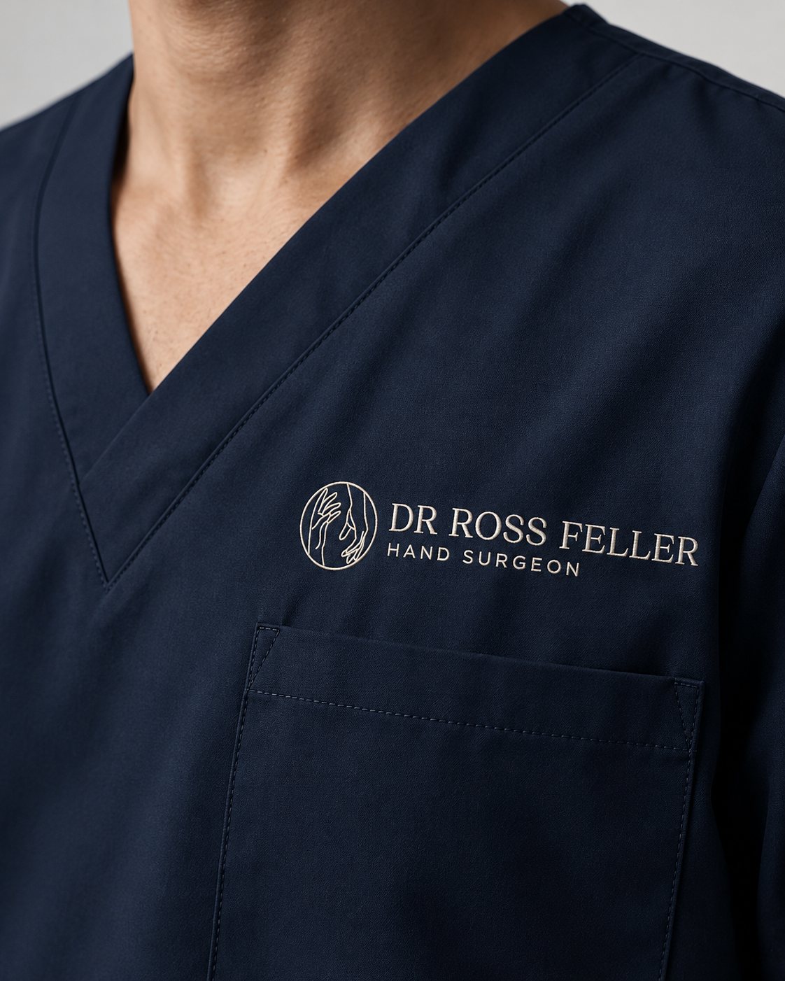 Navy scrubs embroidered with the Dr Ross Feller logo